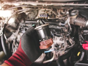 Close up of the EGR exhaust gas recirculation in the auto mechanic hand, automotive part concept.