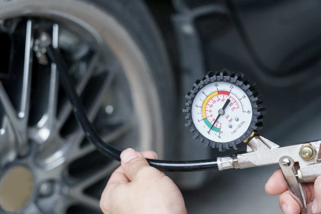 Close up mechanic inflating tire hand holding gauge pressure for checking and filling air in car tire. Automobile concept.