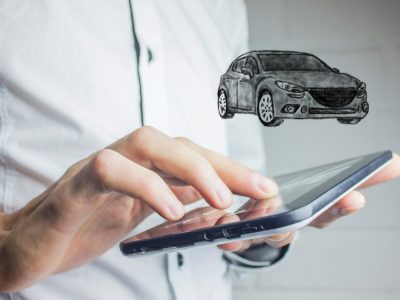 man holding a tablet with an image of a car