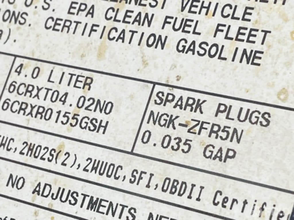 emissions sticker showing the brand and gap recommended for spark plugs