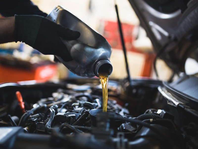 Close up hands of unrecognizable mechanic doing car service and maintenance.