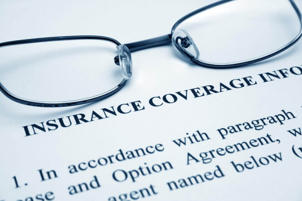 Insurance coverage printed on paper with eyeglasses placed on top of the paper