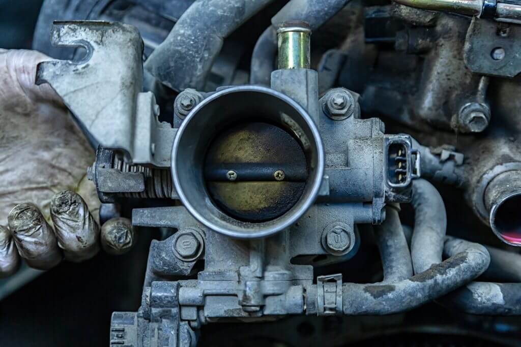 Close-up of the engine, throttle, raditor. Engine breakdown: contaminated throttle of an old car
