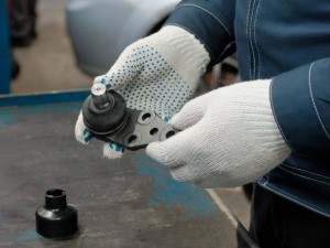 Ball joint in the hands of a car mechanic close-up.