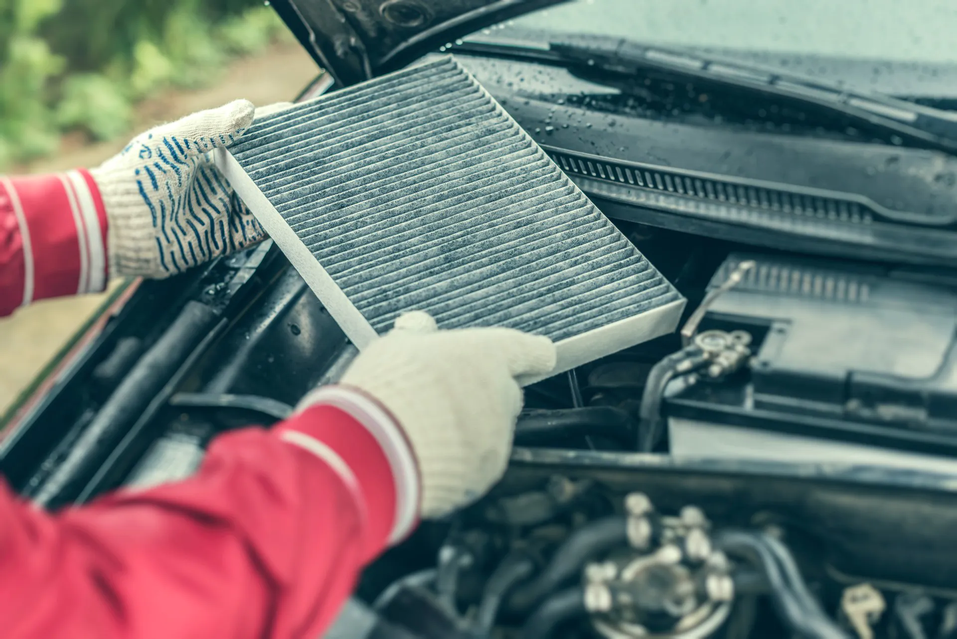 The auto mechanic replaces the car's interior filter.