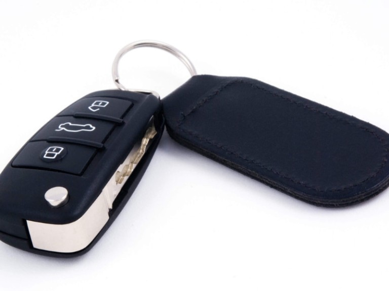 car key with leather fob and remote central locking against a white background
