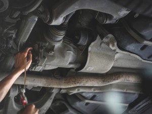 Auto Mechanic filling rear differential fluid.