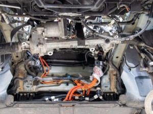 Bottom view of a disassembled Tesla Model 3, with subframe and electric motor removed, for repair.