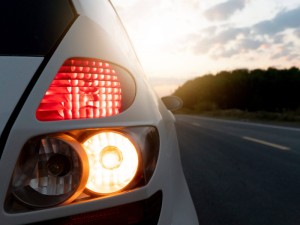 Close up tail lights of white car on asphalt road with sunlight