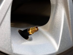 Tire valve stem on car wheel. Vehicle safety, tire wear, fuel mileage and winter checkup concept.