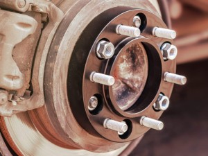 wheel spacer with studs for the car mounted on the wheel hub auto tuning, close-up.