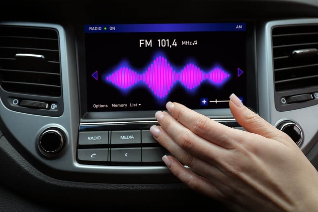 Woman tuning into a radio station in car