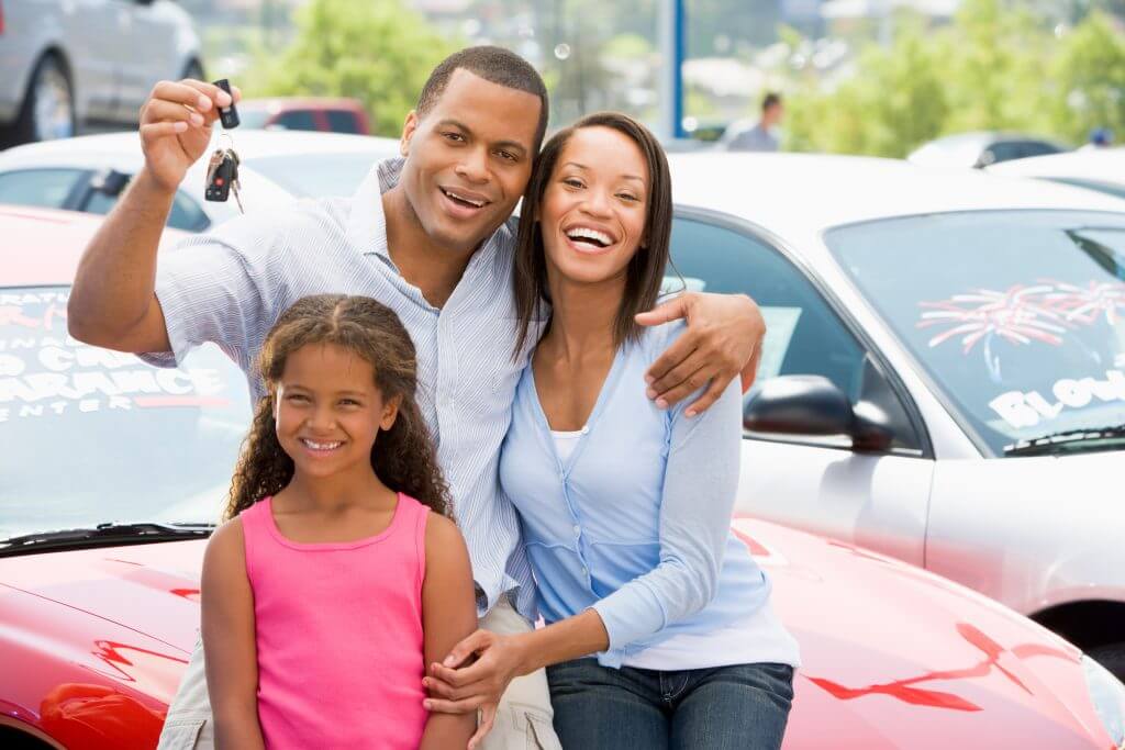 Family collecting new car from lot