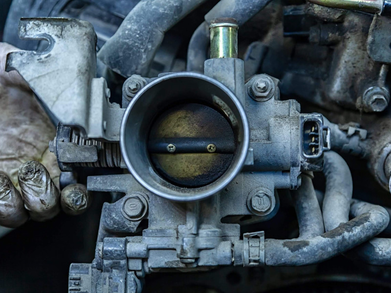 Close-up of the engine, throttle, raditor. Engine breakdown: contaminated throttle of an old car