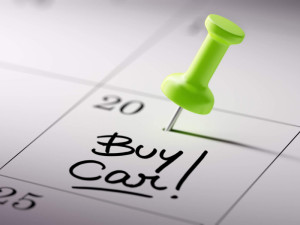 Concept image of a Calendar with a green push pin. Closeup shot of a thumbtack attached. The words Buy Car written on a white notebook to remind you an important appointment.