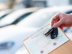 Documents for selling a car, hand holding a key and clipboard