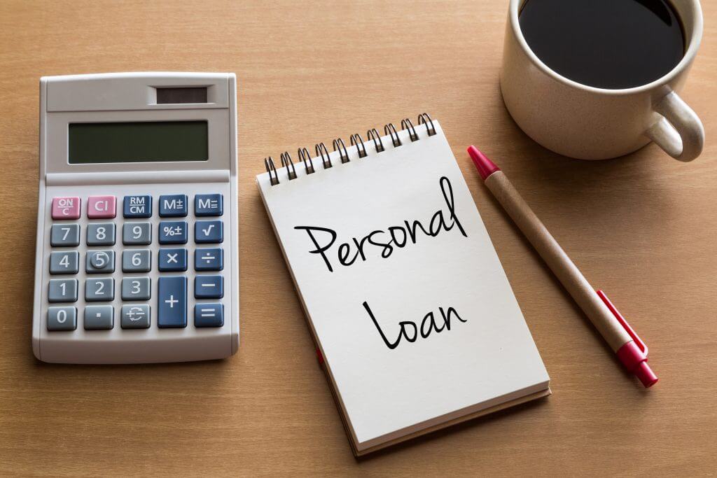 notepad with the word personal loan on a desk