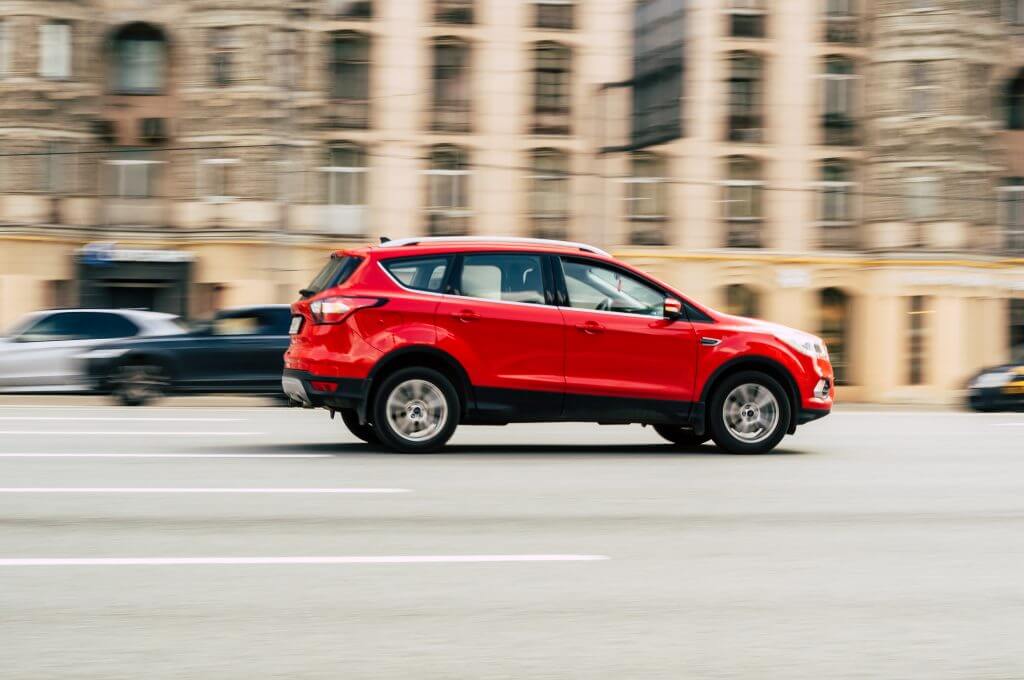 Red Ford Kuga car moving in the street