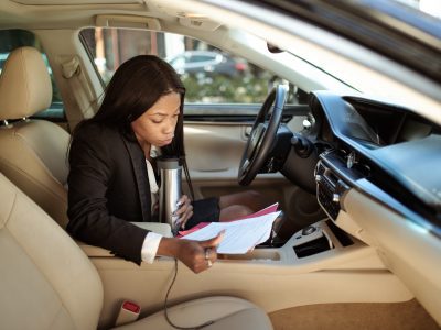 Woman reading a document inside a car