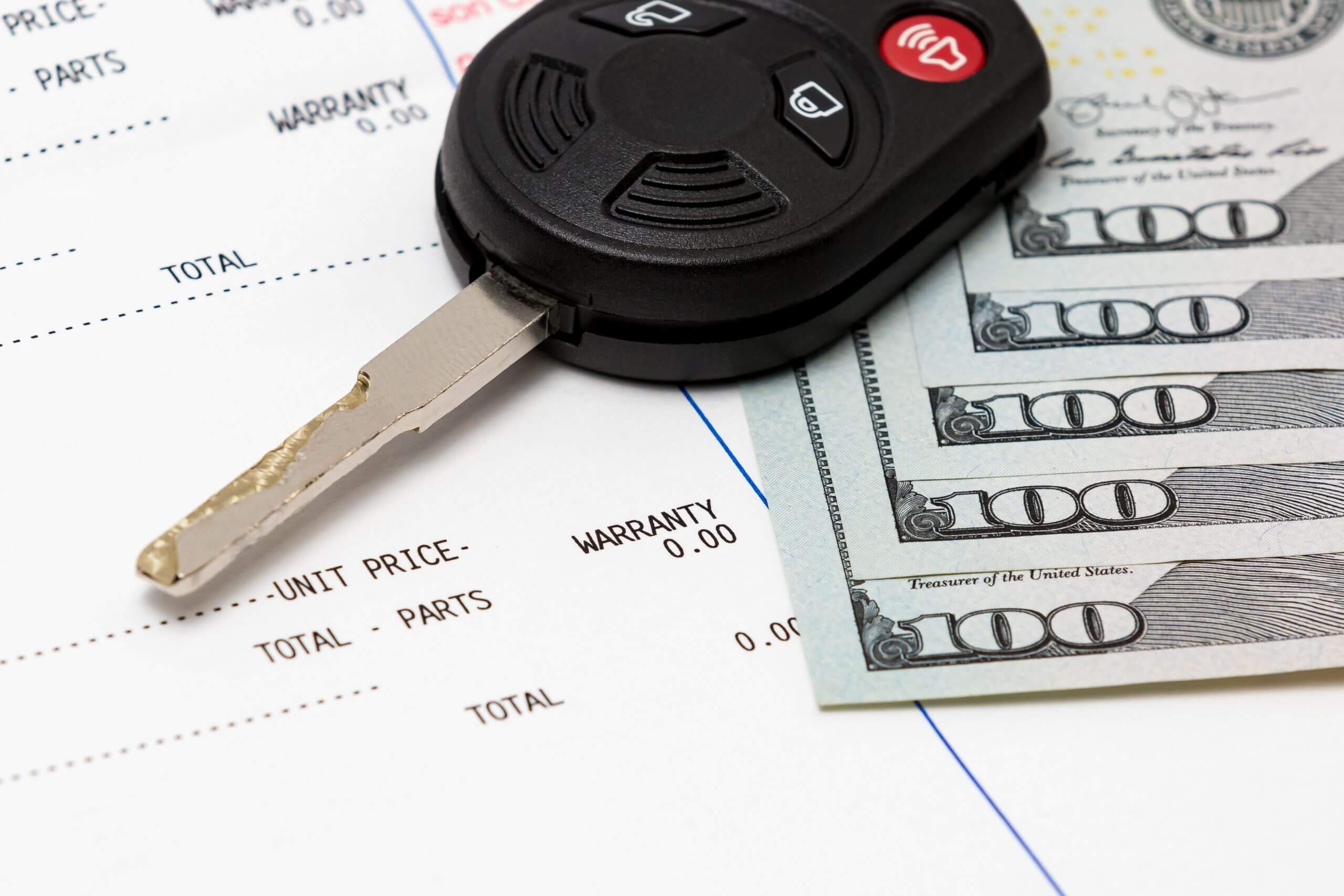Car key, vehicle warranty repair bill and 100 dollar bills cash.
