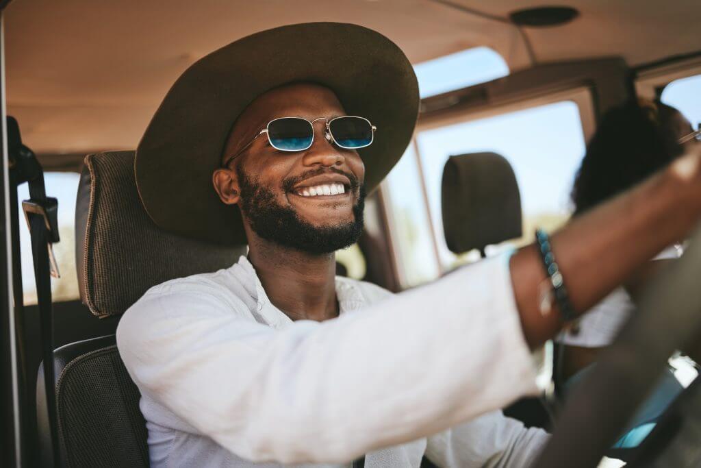 Travel, road trip and happy black man driving a caravan on a summer vacation, journey or adventure. Happiness, freedom and African guy with a smile on a drive to a holiday destination in.