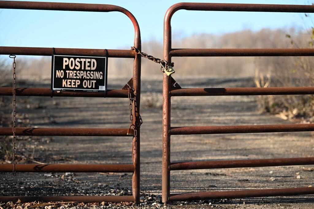 posted no trespassing on a metal gate 