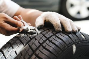 mechanic repair a tire puncture from a nail or screw. car repair and maintenance concept
