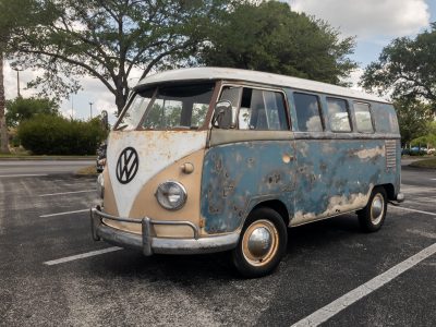 Front View of a Classic Old Rusty Camper Van Parked at a Mall Parking