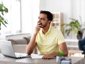 man wondering about something in front of a laptop