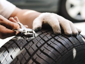 mechanic repair a tire puncture from a nail or screw. car repair and maintenance concept