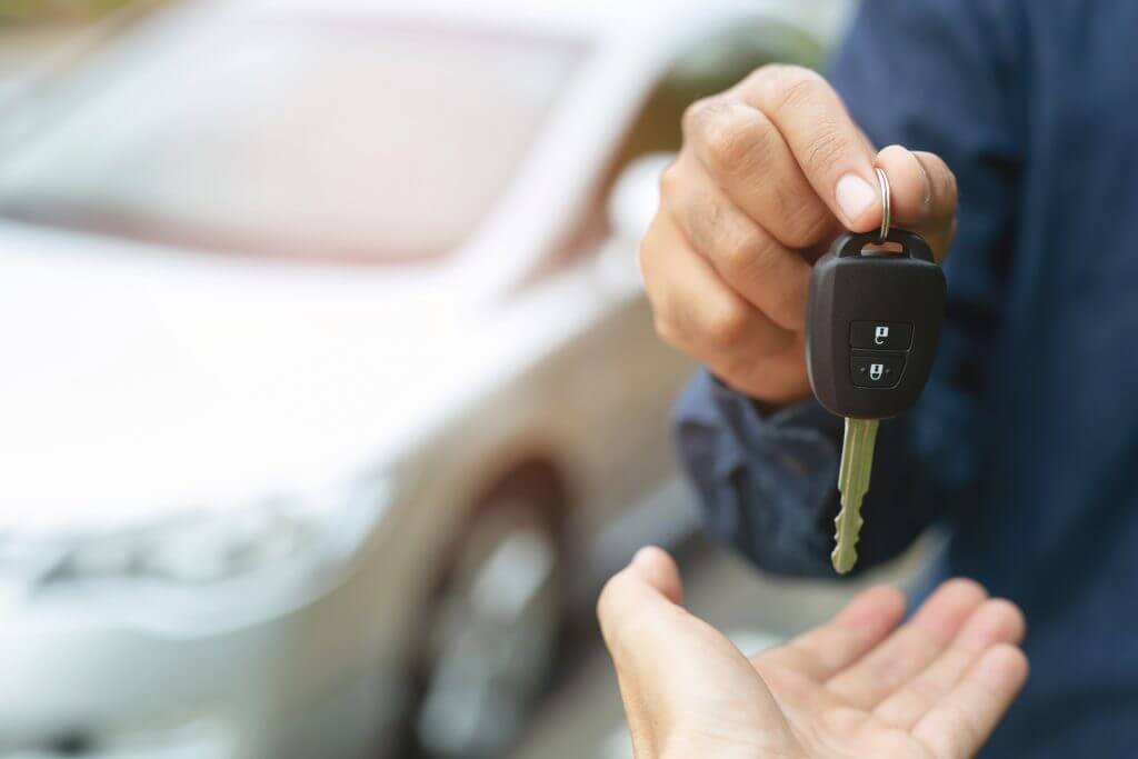 Car key, businessman handing over gives the car key to the other