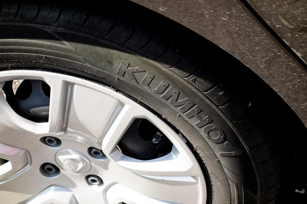 KARVINA, CZECH REPUBLIC - SEPTEMBER 13, 2020: The detail of a brand new Kumho tyre on a brown dirty Dacia car