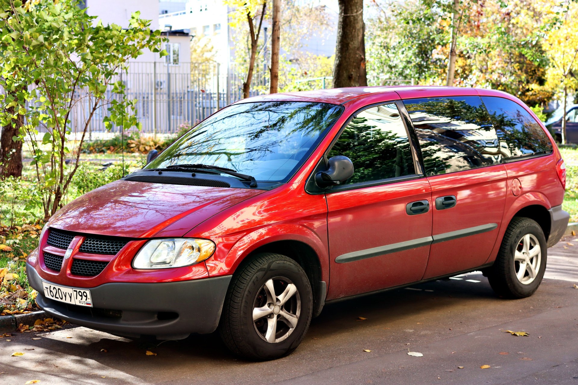 family passenger red car Dodge Grand Caravan is parked in the yard