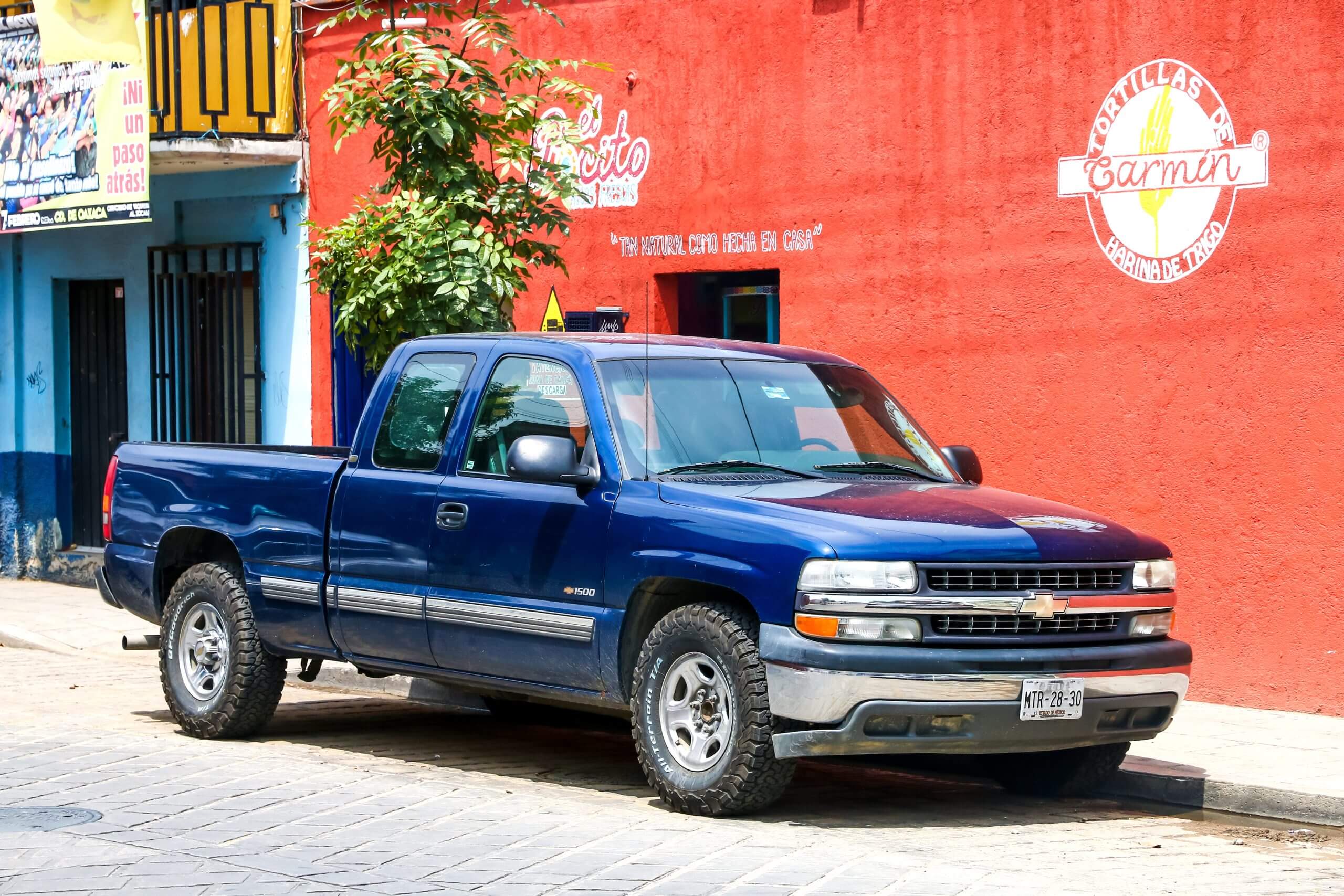 Blue Chevrolet Silverado Pickup truck  in the city street.