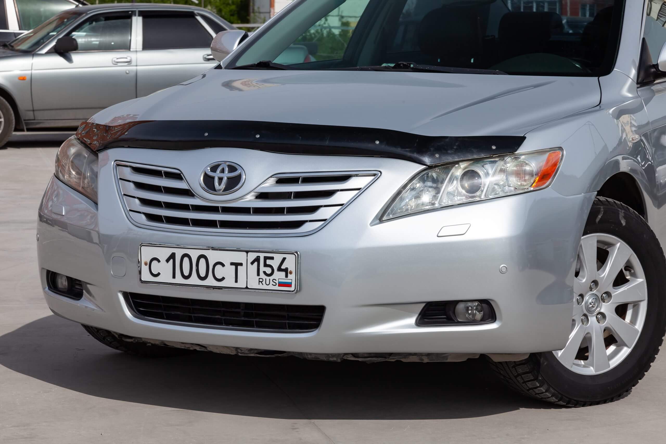  Front view of Toyota Camry 2006 in silver color in a sunny day on parking