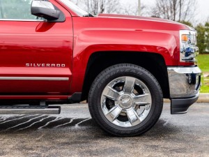 A side picture of a red and rain covered 2017 Chevrolet Silverado 1500 LTZ 4WD.