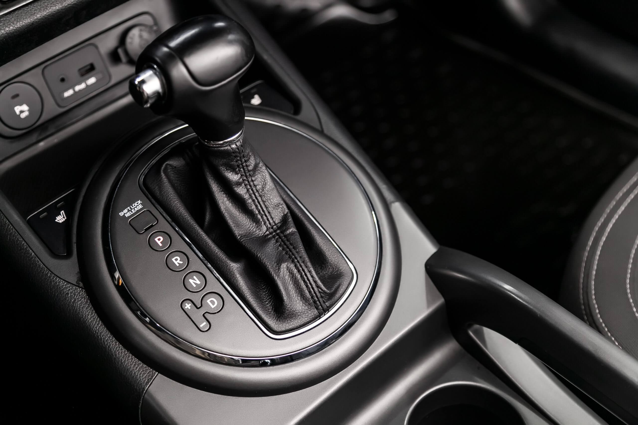 Close up of the automatic gearbox lever, blackinterior car; Automatic transmission gearshift stick