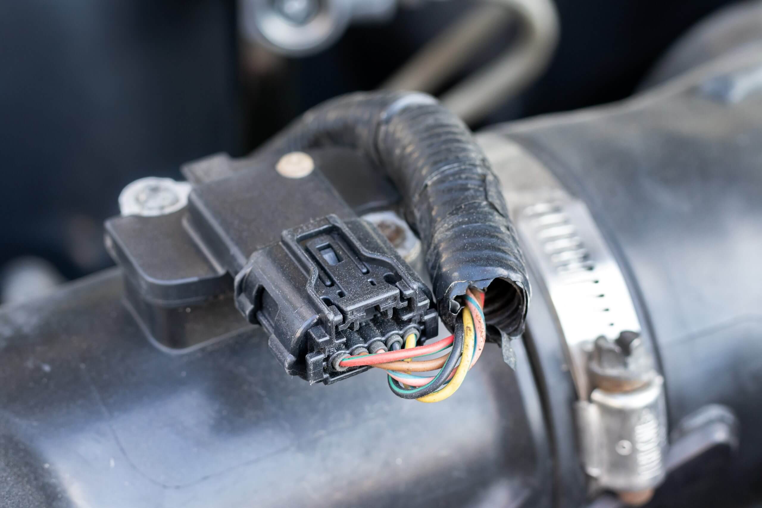 Mass air flow (MAF) sensor under the open hood of a car - measures the air flow in the engine to give the correct readings on the engine control unit (ECU) to adjust the fuel-air mixture