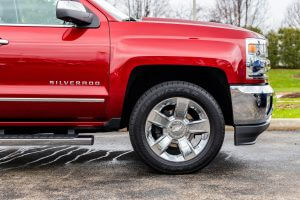 A side picture of a red and rain covered 2017 Chevrolet Silverado 1500 LTZ 4WD.