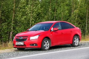 Novyy Urengoy, Russia - August 11, 2019: Red motor car Chevrolet Cruze at the countryside.