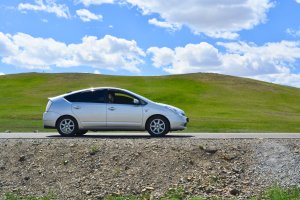 Toyota Prius parked against a green landscape