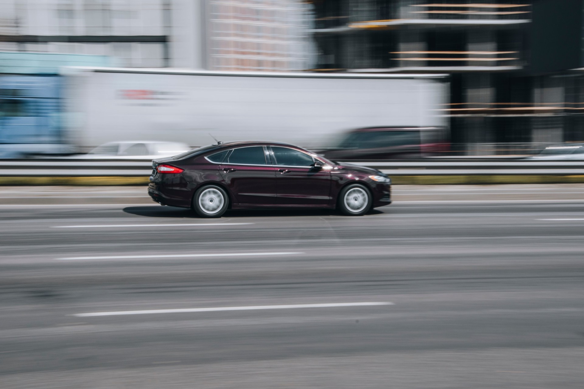 2013 Purple Ford Fusion car moving on the street.
