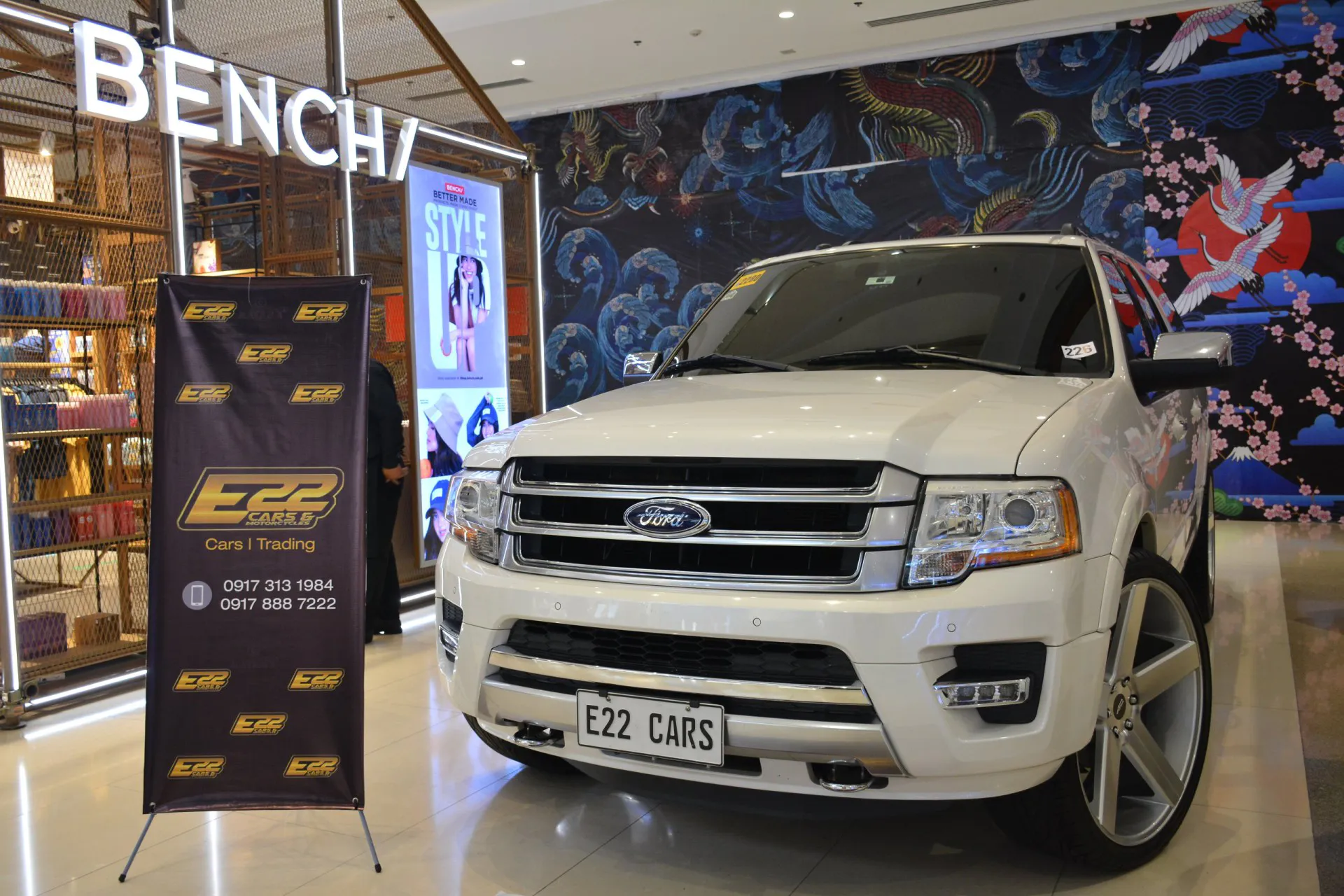 A white 2015 Ford Expedition at a car show parked inside a mall
