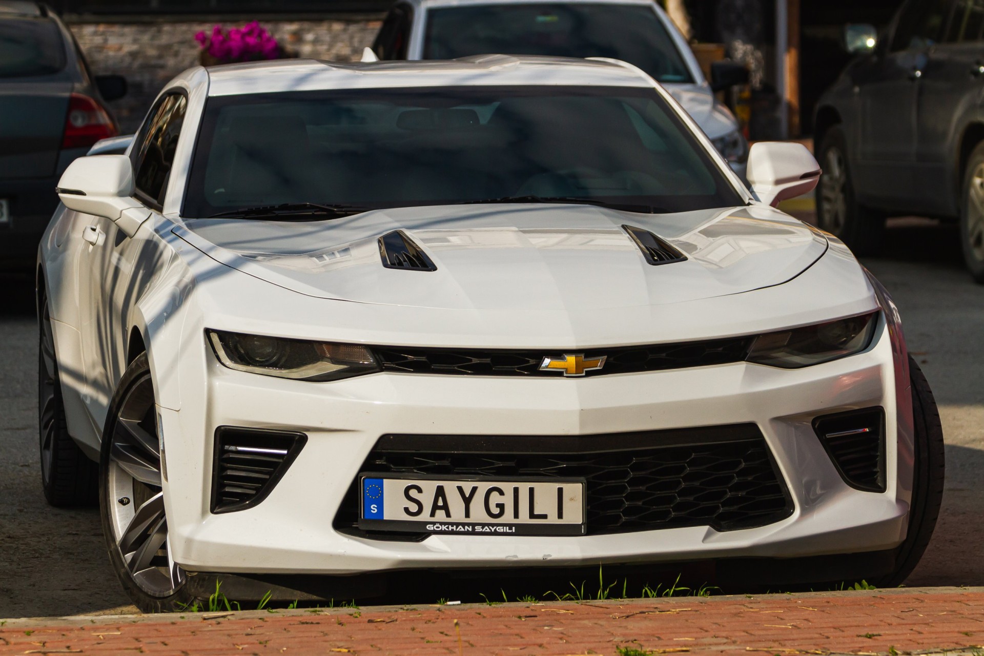 2016 White Chevrolet Camaro parked on the street on a warm day
