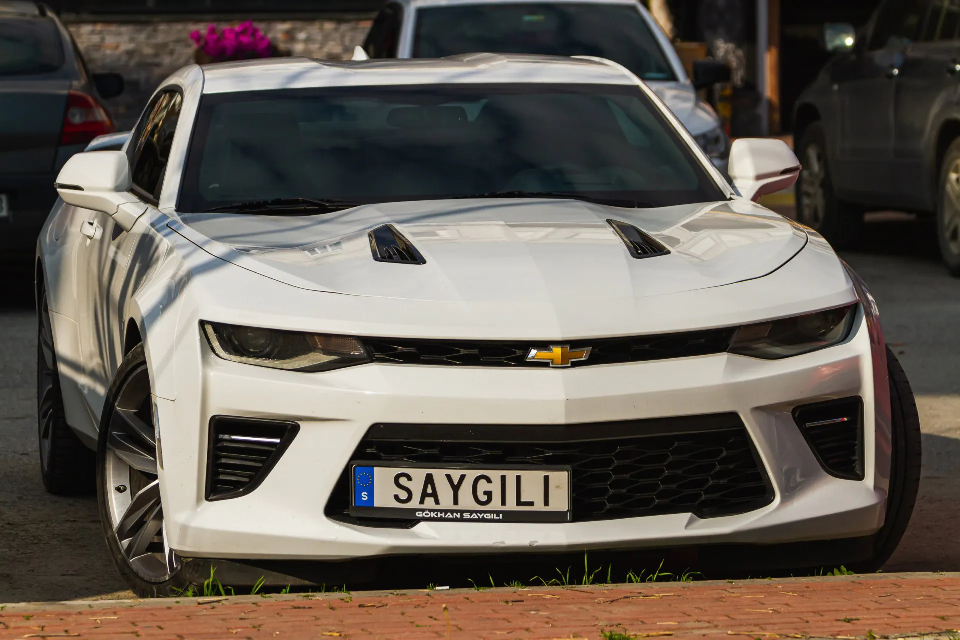 2016 White Chevrolet Camaro parked on the street on a warm day