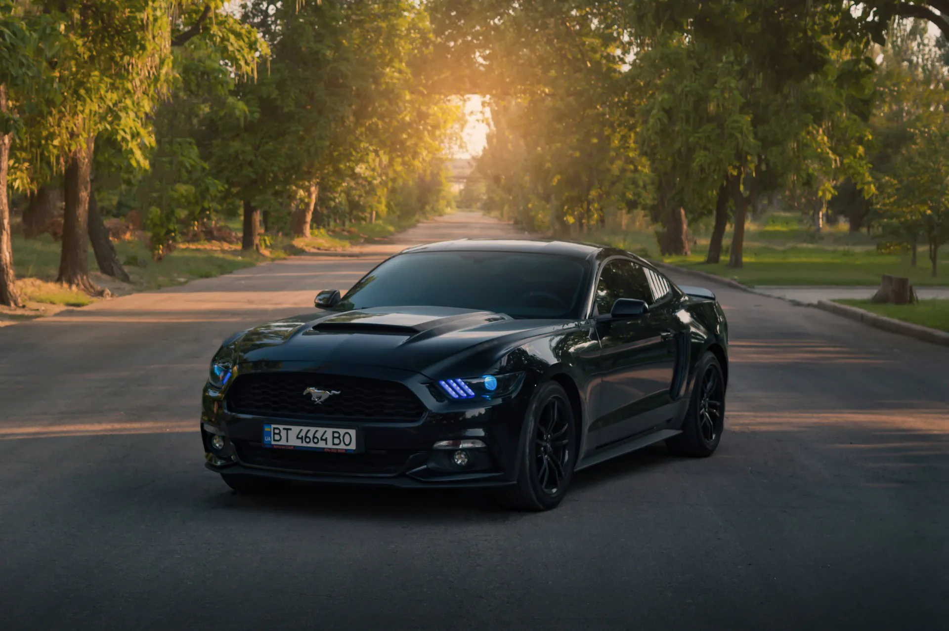 2016 Ford Mustang in a black color with blue headlights.