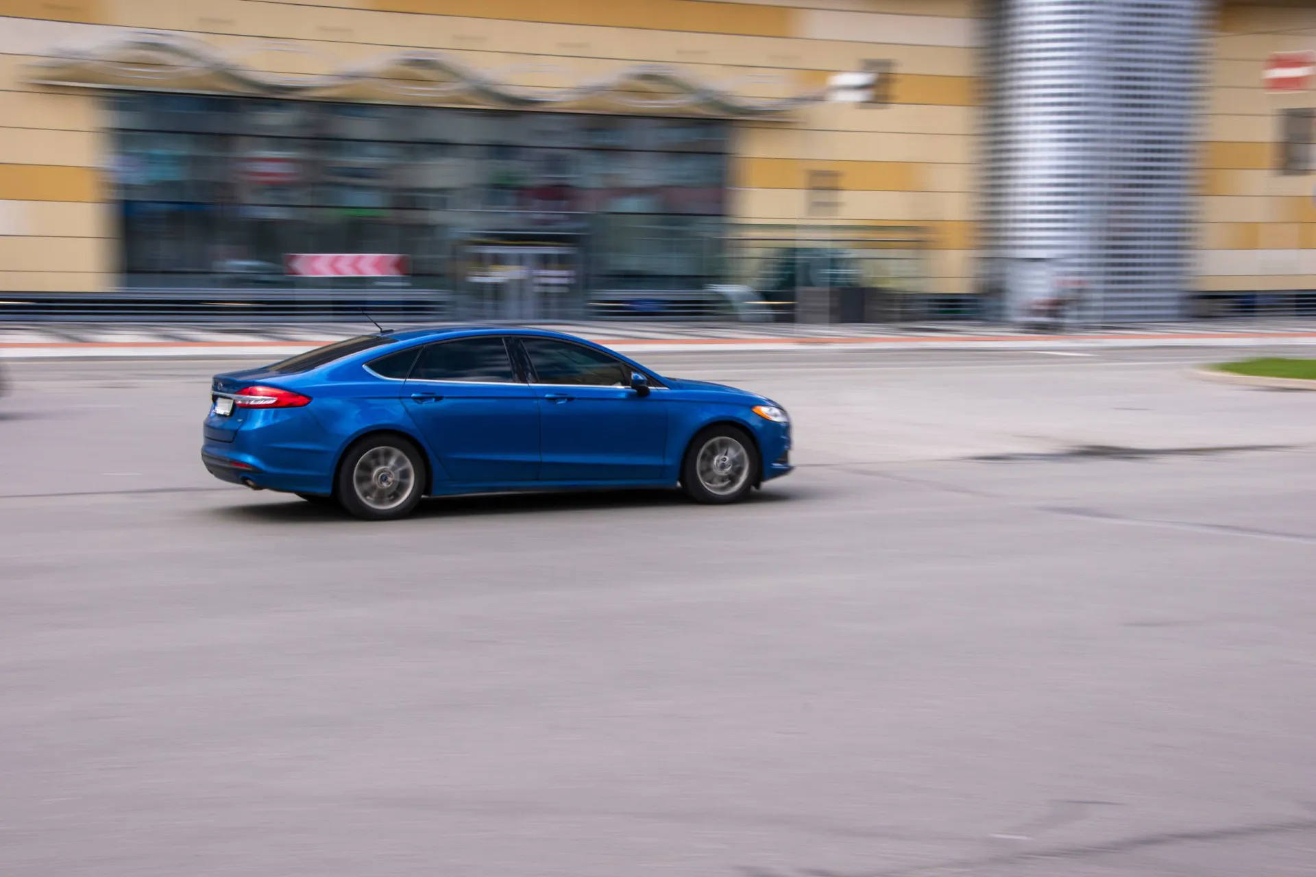 Blue Ford Fusion (North America) car moving on the street. 