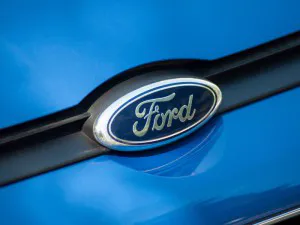 Closeup of Ford logo on blue car front parked in the street