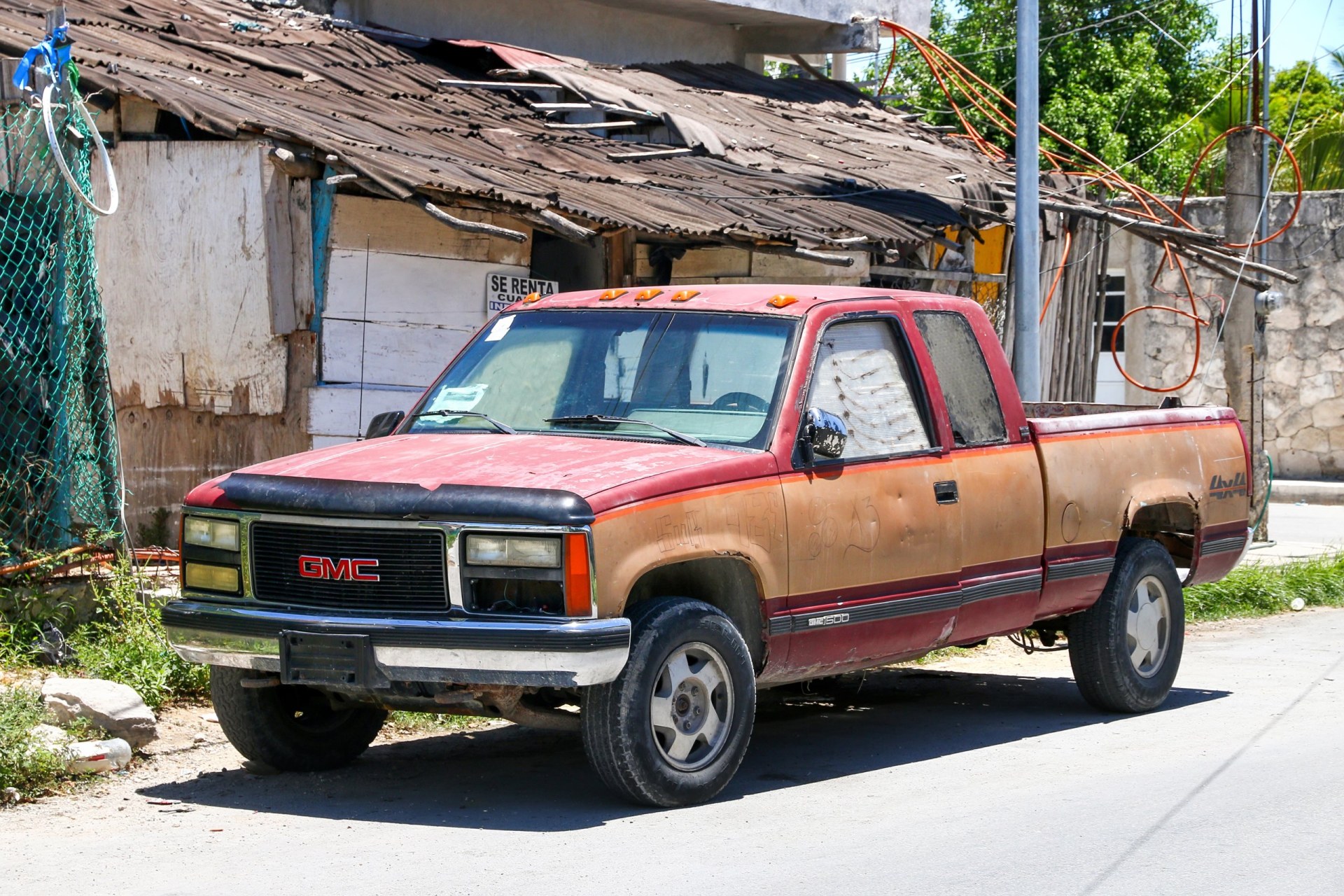 Old pickup truck GMC Sierra 1500 in a city street.