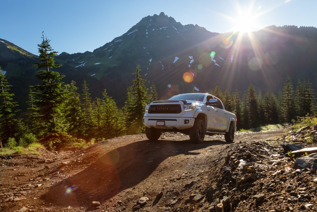 Toyota Tacoma riding on the 4x4 Offroad Trails in the mountains during a sunny summer morning.